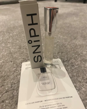 L'Atelier Parfum Woodylicious EdP 5ml - Upptäck Woodylicious – en floral eau de parfum med noter av ros, vanilj och sandelträ. Smidig 8 ml sprayflaska, perfekt att ta med överallt. Perfekt för dig som vill testa något nytt och fräscht.