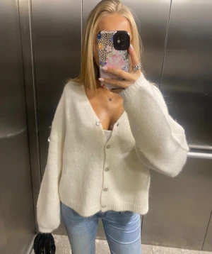 Vit stickad kofta med knappar - Mysig vit stickad kofta med v-ringning och stora, långa ärmar. Säljer för jag inte använder den längre, skriv vid intresse!❤️