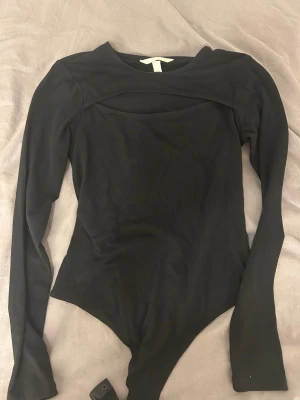 Svart body  - Svart body med unik urklippning över bröstet. Använd fåtal gånger. Från HM storlek S