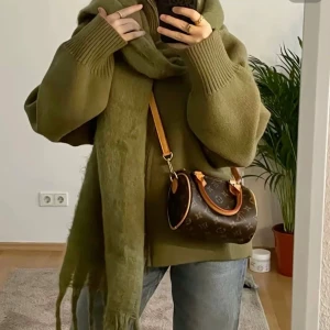 Olivgrön fluffig halsduk med fransar - Pris kan diskuteras! Säljer en olivgrön, lång och fluffig halsduk med grova fransar i ändarna. Halsduken är stickad och har en mjuk, cozy vibe som passar perfekt när det är kallt ute. Färgen är dämpad och ger en chill look till din outfit.