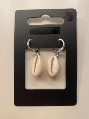 Snäck örhängen  - Säljer ett par jättesöta snäckörhängen, helt oanvända. De är ej i äkta silver och snäckan är inte riktigt 💕 De väger inte alls mycket och är perfekt för söta outfits 🫶