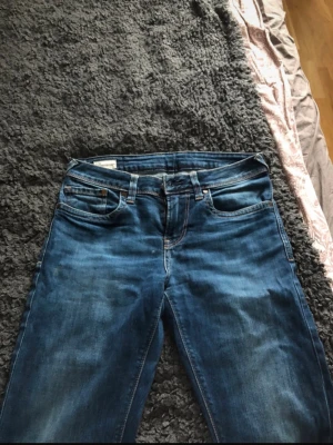 Blå slim low waist Peppe jeans  - Snygga blå jeans från peppe i slim fit-modell med låg midja. Klassisk femficksdesign, smal passform och cool tvättad look. Perfekta för dig som gillar en tajtare stil och vill ha ett par jeans som sitter snyggt hela dagen.