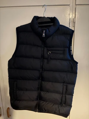 Hugo Boss dunväst - Skön och varm Hugo Boss dunväst. Storleken står som XL men skulle säga att den är mer åt L. Använd enstaka gånger. Nästintill nyskick. Pris kan diskuteras!