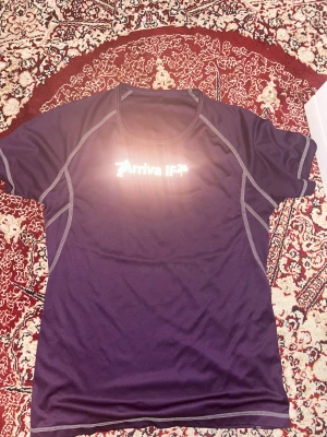 Mörkblå Arriva IF t-shirt i polyester - Sportig mörkblå t-shirt från Arriva IF med reflekterande tryck fram och bak. Snygga grå sömmar ger en cool kontrast. Tillverkad i mjukt och lätt polyester, perfekt för träning eller aktivitet. Klassisk rund hals och korta ärmar.