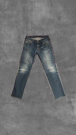 Nudie Jeans Dry Denim - Detta är ett par Nudie jeans i modellen slim Jim och med storleken 31,34 De har en snygg denim fading efter alla års användning men är trotts detta i ett bra skick Ändå defekterna är: håll i båda fickorna och en seg dragkedja (som dock har en tillfällig lösning)   Hör gärna av dig med frågor och prisförslag!