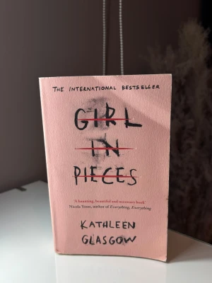 Bok Girl in pieces - En bok med titeln girl in pieces. Har mycket slitage och böjda kanter och två fläckar på baksidan men sidorna är inte påverkade. Boken är på engelska