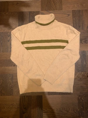 Polotröja från Riley  - Säljer en riktigt snygg beige polotröja från Riley i bra skick. Ränder framtill. Varm perfekt för vinter. Tröjan är i XL men passar nog också L så vid frågor, hör av dig! 