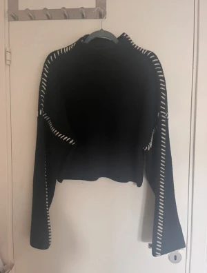 Svart stickad tröja med vita detaljer - Svart stickad tröja med lång ärm och vita detaljer från hm. Pris kan diskuteras.🥰