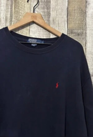 Mörkblå långärmad tröja Polo Ralph Loran - Snygg mörkblå långärmad tröja från Polo Ralph Lauren med klassisk rund hals och broderad logga på bröstet. Tröjan är i mjuk bomull och har en stilren, normal passform. Perfekt för dig som gillar enkel och tidlös design med en touch av preppy. Köptes för 1 månad sen för 999
