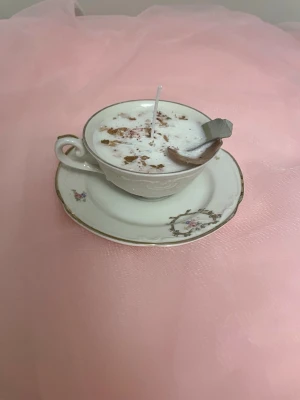 Doftljus i vaniljdoft i en vit tekopp med blommor på nr 2  - Det här ljuset är gjort av återanvändbara material. Tekoppen är köpt secondhand och stearinet är från kyrkor som tänkte slänga det. Det här ljuset har en svag doft utav vanilj, så känsliga även kan använda det. Det här ljuset har även torkade blommor på som dekoration. Det finns fler av denna design på hemsidan om man vill köpa sets. 