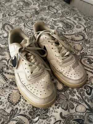 Nike sneakers  - Ett par vita Nike sneakers som är tydligt använda. Skorna är slitna och smutsiga, med missfärgning på sula. Perfekt som extra skor eller för dig som vill fixa och rengöra själv.