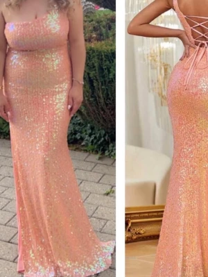 Festklänning  - Säljer en superfin glittrig långklänning i peach med paljetter. Klänningen har axelbandslös design framtill och snörning i ryggen för snygg passform. Perfekt för bal eller fest och ger en riktigt glam känsla. M-L💕