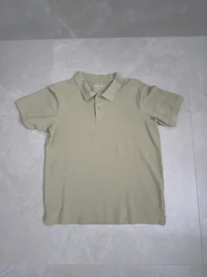 Beige pikétröja från Take Off - Säljer en stilren beige pikétröja från Take Off i storlek S. Tröjan har klassisk krage, korta ärmar och två knappar framtill. Materialet känns som mjuk bomull och färgen är neutral och lättmatchad. Perfekt för en chill och enkel look.