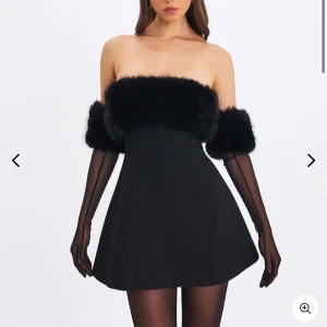Svart axelbandslös klänning Miss Circle - Axelbandslös elegant klänning från Miss Circle med fejkpälsdetaljer upptill. Endast använt en gång och är i väldigt bra skick. 