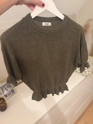 Grön stickad topp  - Trekvartsärmad topp med volanger som ej kommer till användning 