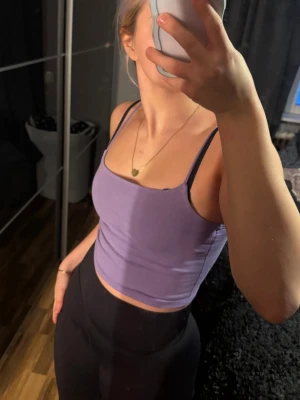 Lila croppad linnetopp  - Säljer en lila croppad linnetopp från New Yorker med smala axelband och rak halsringning. Toppen är i mjuk bomullsblandning med lite stretch för en bekväm passform. 