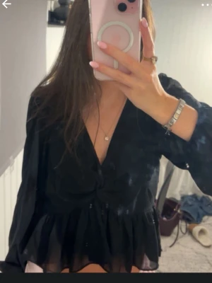 Blus - Svart blus som är öppen i ryggen. 