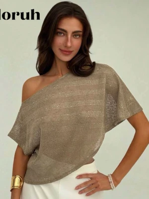 Beige glittrig offshoulder topp - Säljer en beige glittrig topp med offshoulder-design. Toppen är lös och har korta ärmar, tillverkad i ett tunt och lätt syntetmaterial som ger en snygg transparent effekt. Perfekt för dig som vill ha en chill men ändå trendig look.