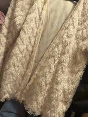 Beige teddyjacka från H&M Divided - Säljer en fluffig och mysig beige teddyjacka från H&M Divided i storlek L. Jackan har öppen front och ett coolt, lurvigt material som ger en trendig look. Perfekt för dig som vill ha något både snyggt och bekvämt till hösten eller vintern.