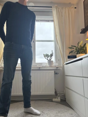 Mörkblå stickad tröja med kabelmönster - Säljer en mörkblå stickad tröja med klassiskt kabelstickat mönster. Tröjan har rund halsringning och långa ärmar, perfekt för kyligare dagar. Snygg och enkel att matcha med jeans eller andra byxor.