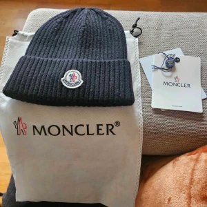Svart Ribbad Moncler mössa  - Ny oanvänd svart mössa från Moncler med ribbad struktur och klassisk Moncler-logga framtill. Pris kan diskuteras! 