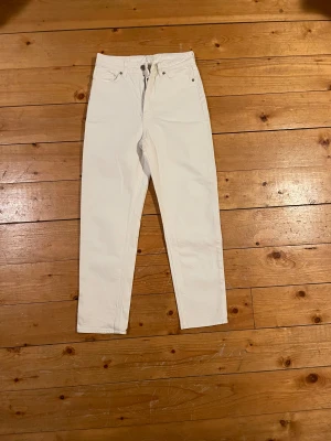 Jeans i strl 36 - Säljer ett par vita jeans från H&M i storlek 36. De har klassisk femficksdesign, raka ben och normal passform. Byxorna är tillverkade i bomull och har silvriga nitar vid fickorna. Perfekta för en clean och fräsch look✨