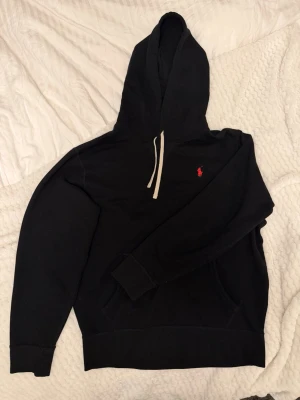 Svart Ralph Lauren hoodie - Hoodie från Ralph Lauren, nypris 2295kr. Den är verifierad med qr koden. Jag säljer produkten för att jag tyckte den var för kort. Jag är 188cm för referens. 