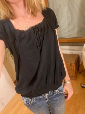 Gullig svart blus / t-shirt med puffärm - Jag älskar denna t-shhirt så mycket, den är så himla söt! Urringningen är också så fin. Modellen på tröjan går typ in vid midjan / höften. 