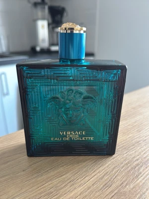 Versace Eros Eau de Toilette 200ml - Versace Eros Eau de Toilette, 200ml. En ikonisk doft i snygg blå flaska, perfekt för dig som vill sticka ut. Tillverkad i Italien.  Toppnoter – Mynta, citron och grönt äpple Mellannoter – Ambroxan, geranium och tonkaböna Basnoter – Ceder, ekmossa, vetiver och vanilj