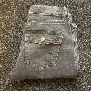 Grå bootcut jeans från Perfect Jeans - Snygga grå jeans från Perfect Jeans i storlek 40. Modellen har klassisk femficksdesign med en extra ficka med lock bak och bootcut-ben. Jeansen är tillverkade i denim och har en cool, lite tvättad look.