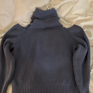 Grå stickad polotröja från Zara - Säljer en blå/grå ribbstickad polotröja från Zara med coola cut out-detaljer vid axlarna. Super bra skick! 