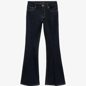 Mörkblå bootcut jeans med hög midja - Snygga mörkblå jeans med bootcut och medel hög midja som endast är använda en gång. Klassisk femficksmodell med markerade sömmar framtill och bakfickor. Jeansen har en rak passform upptill och utsvängda ben, vilket ger en riktigt trendig siluett. 