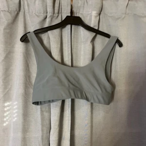 Grön bikini topp från Nelly - Säljer en stilren grön bikini från Nelly i mjukt och stretchigt material. Toppen har breda axelband och en klassisk, rundad urringning både fram och bak. 