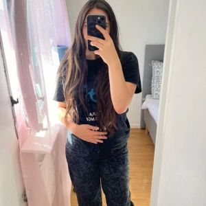 Svarta mönstrade mjukisbyxor - Säljer ett par svarta mjukisbyxor med diskret mönster i mörkare nyans. Byxorna har en avslappnad passform och resår i midjan för extra komfort. Perfekta för chill dagar hemma eller när du vill vara bekväm men ändå se snygg ut.