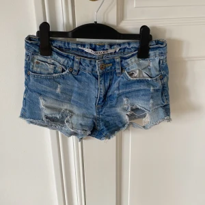 Blå jeansshorts  - Snygga låg midjade blå jeansshorts från Fabulous med slitna detaljer och fransig kant.💕