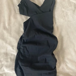 Svart omlottklänning från Zara XS - Snygg svart omlottklänning från Zara i storlek XS. Klänningen har en figurnära passform med omlottdetalj upptill. Materialet är mjukt och lätt, perfekt för dig som gillar stilrena och enkla plagg med en twist.
