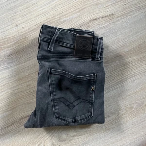 Replay svarta jeans med raka ben - Svarta jeans från Replay med klassisk femficksdesign och snygga detaljer på bakfickan. Jeansen har raka ben och normal passform, tillverkade i mjukt denimtyg. Perfekta för en stilren och avslappnad look.