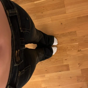 Mörkblå bootcut jeans från 157 - Säljer ett par mörkblå jeans från 157 med bootcut-modell och låg midja. Jeansen har markerade sömmar, stora framfickor och klassiska bakfickor. Materialet är jeans med lätt slitning för en cool look. Perfekta för dig som gillar snygg passform.