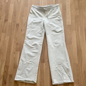 Vita byxor med snörning - Vita byxor med rak passform och elastisk midja med snörning.