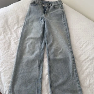 Ljusblå raka jeans från Bubbleroom - Säljer ett par ljusblå jeans från Bubbleroom med klassisk femficksdesign och raka ben. Jeansen har hög midja och är tillverkade i denim med snygg tvättad look. Perfekta till en crop top eller hoodie för en chill vibe.