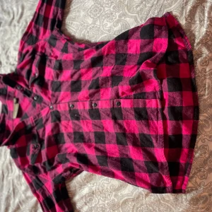 Rutig rosa och svart skjorta Euro-Hunt - Snygg långärmad skjorta från Euro-Hunt i rosa och svart rutigt mönster. Skjortan har knappar framtill, klassisk krage och är tillverkad i mjuk bomull. Perfekt för dig som gillar en avslappnad men ändå cool stil.