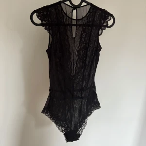 Spets body - Säljer en svart body i spets från H&M. Storlek XS. Använd ett fåtal gånger. Superfint skick!!