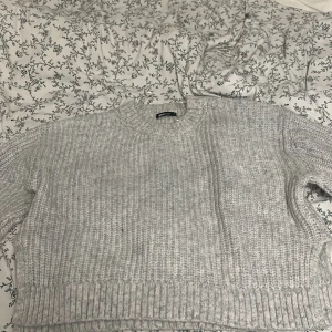Ljusgrå stickad tröja Gina Tricot - Mysig ljusgrå stickad tröja från Gina Tricot i storlek M. Tröjan har en klassisk rund halsringning, ribbade muddar och är långärmad. Perfekt för lager-på-lager och chill dagar. Enkel att matcha med jeans eller kjol.