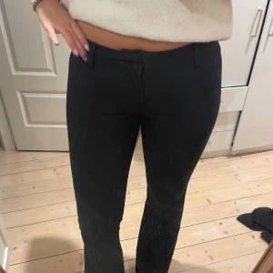 Svarta kostymbyxor med bootcut - Snygga svarta kostymbyxor med bootcut och låg midja. Byxorna har klassiska hällor för bälte och stängs med dragkedja och knapp. Storlek M men skulle säga att det är mer som S💓