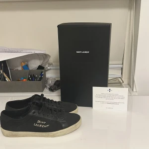 Svarta Saint Laurent sneakers - Feta sl skor köpta från trendsellers. Skick är ungefär 9/10 går att fräscha upp hur enkelt som helst. Inga deffekter, Man får med sig: Dustbag, box, och ett äktighetcertifikat från trendsellers. Pris är ej hugget i sten såklart. Kontakta för mer info om trendsellers