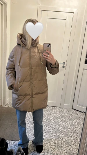 Beige pufferjacka från Zara  - Säljer en beige pufferjacka från Zara i storlek XS. Jackan har en stor huva med snörning, dragkedja framtill och två sidofickor. Den är quiltad och har en loose passform, perfekt för kalla dagar. Materialet är syntet och jackan är riktigt mysig och varm💓