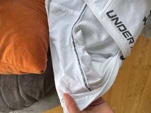 Under Armour vindjacka vit - Snygg vit vindjacka från Under Armour med huva. Kommer ej till användning, för liten. Stilren design med svart text längs dragkedjan. Windbreaker 