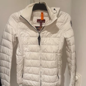 Vit dunjacka från Parajumpers S - Säljer en superlätt och snygg vit dunjacka från Parajumpers i storlek S. Jackan har quiltad design, dragkedja framtill, hög krage och coolt patch på ärmen. Perfekt för dig som vill ha en stilren och varm jacka med streetkänsla. För mer bilder är det bara att skriva. Äkta! Nypris idag kostar 5200kr.