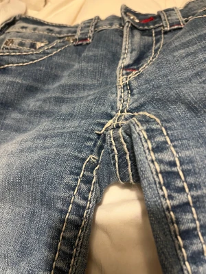 True religion jeans - Säljer dessa sjukt snygga jeans från true religion i storlek W23. Köpte på johnells för 1599kr. Sparsamt använda så i väldigt bra skick, tyvärr var en av sömmarna vid innerbenet trasig redan när jag köpte dem (som på bilden)💕