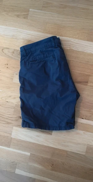 Tommy Hilfiger shorts - Snygga marinblå shorts från Tommy Hilfiger med klassisk design och raka ben. De har fickor fram och bak, knappstängning och bälteshällor.